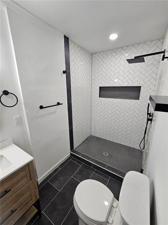 775 Lee Andrews Ave SE, Atlanta, GA 30315 - bathroom featuring toilet, a tile shower, vanity, recessed lighting, and tile patterned flooring