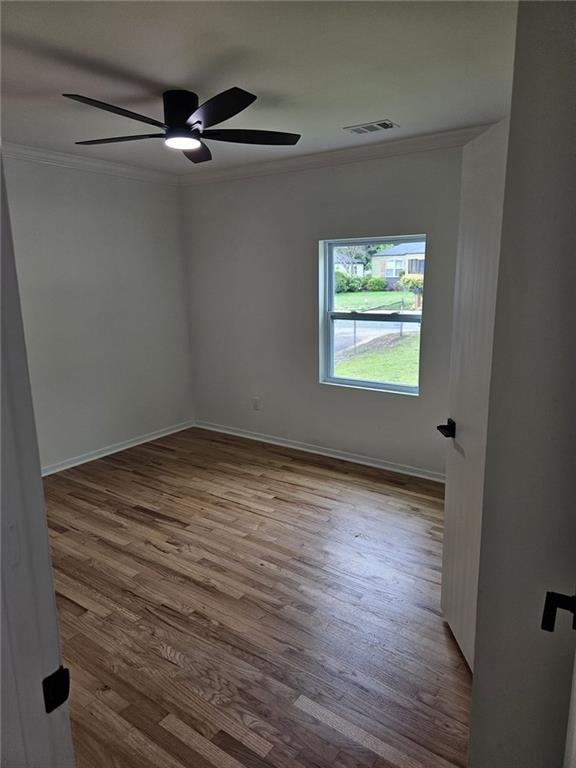 775 Lee Andrews Ave SE, Atlanta, GA 30315 - unfurnished room with ornamental molding, wood finished floors, ceiling fan, and baseboards