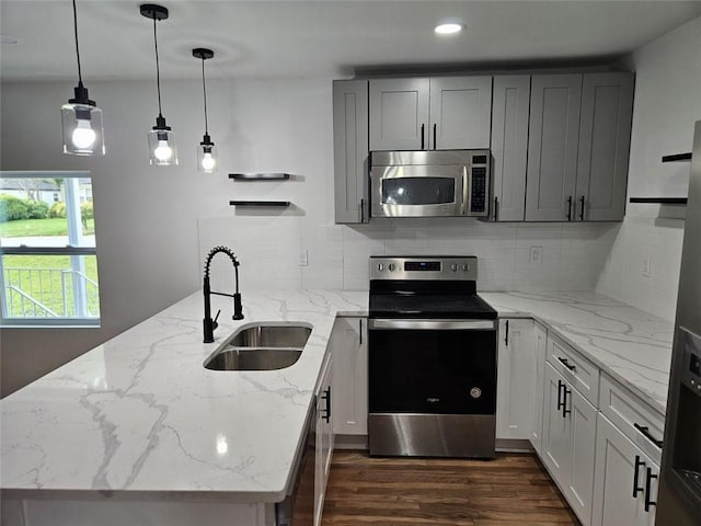 775 Lee Andrews Ave SE, Atlanta, GA 30315 - kitchen featuring appliances with stainless steel finishes, a sink, a peninsula, dark wood-type flooring, and backsplash
