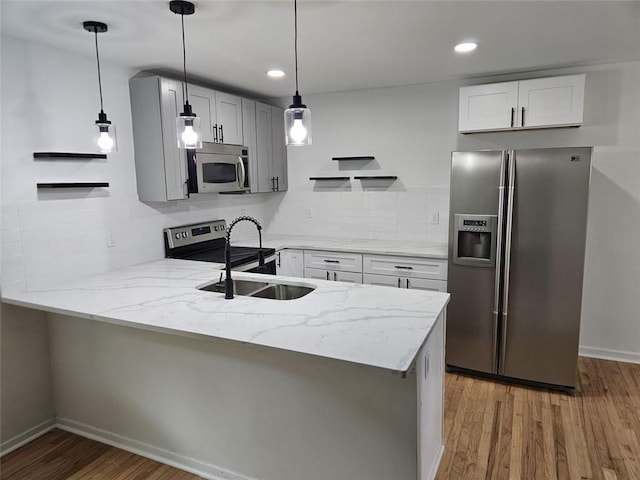 775 Lee Andrews Ave SE, Atlanta, GA 30315 - kitchen featuring stainless steel appliances, a peninsula, a sink, light wood-style floors, and light stone counters