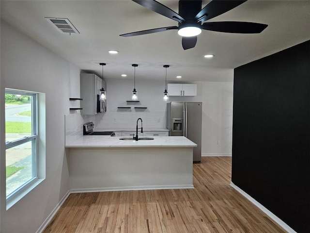 775 Lee Andrews Ave SE, Atlanta, GA 30315 - kitchen featuring a sink, appliances with stainless steel finishes, a peninsula, tasteful backsplash, and light wood finished floors