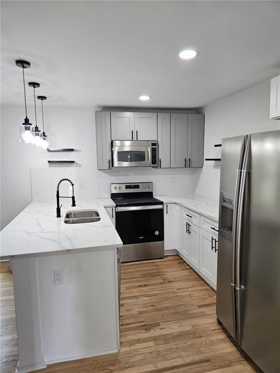 775 Lee Andrews Ave SE, Atlanta, GA 30315 - kitchen with appliances with stainless steel finishes, a sink, a peninsula, light wood finished floors, and recessed lighting