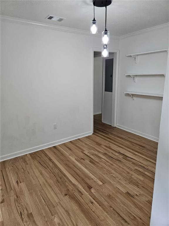 775 Lee Andrews Ave SE, Atlanta, GA 30315 - unfurnished dining area with wood finished floors, baseboards, and crown molding