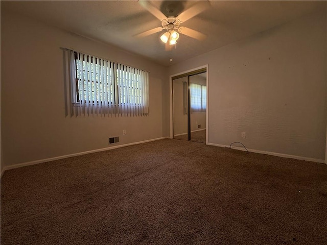 unfurnished bedroom featuring carpet flooring, a ceiling fan, baseboards, visible vents, and a closet