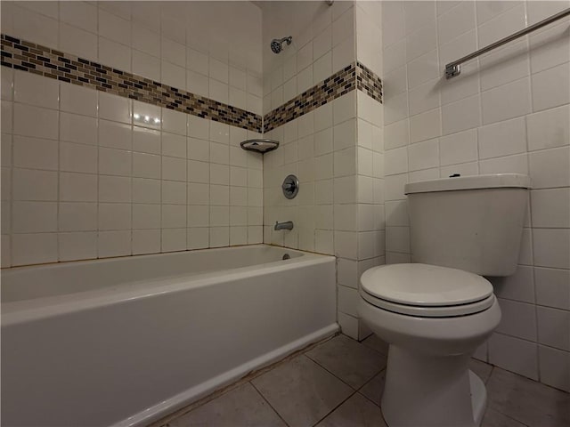 bathroom featuring toilet, shower / bath combination, tile walls, and tile patterned flooring
