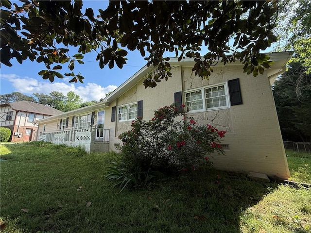 view of property exterior with a lawn and brick siding