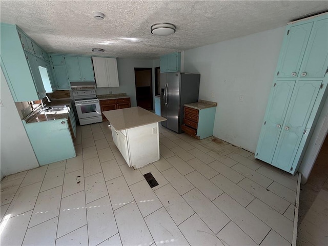 kitchen with a kitchen island, white range with electric cooktop, stainless steel fridge, a textured ceiling, and a sink