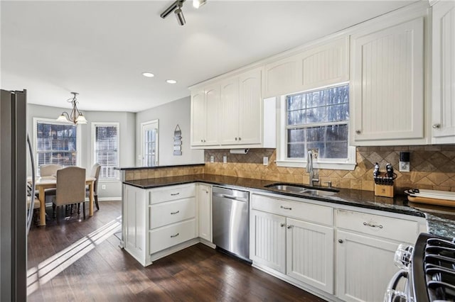 kitchen featuring pendant lighting, white cabinetry, dark hardwood / wood-style flooring, stainless steel appliances, and sink