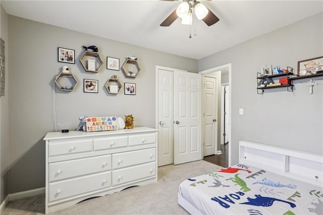 carpeted bedroom with ceiling fan and a closet