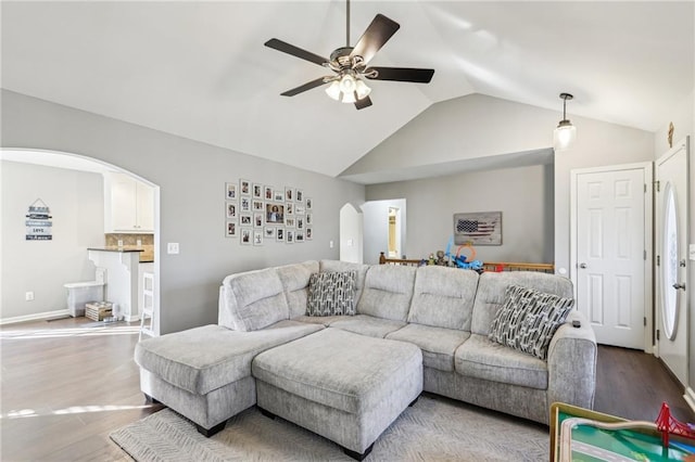 living room featuring ceiling fan, hardwood / wood-style flooring, and vaulted ceiling