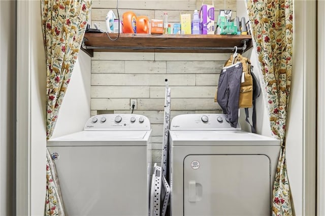 laundry area with wood walls and independent washer and dryer