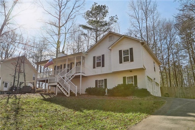 rear view of house with a garage, a porch, and a lawn