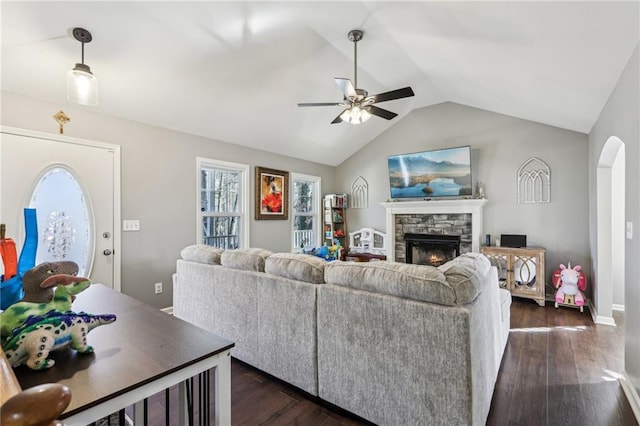 living room with ceiling fan, vaulted ceiling, a fireplace, and dark hardwood / wood-style flooring