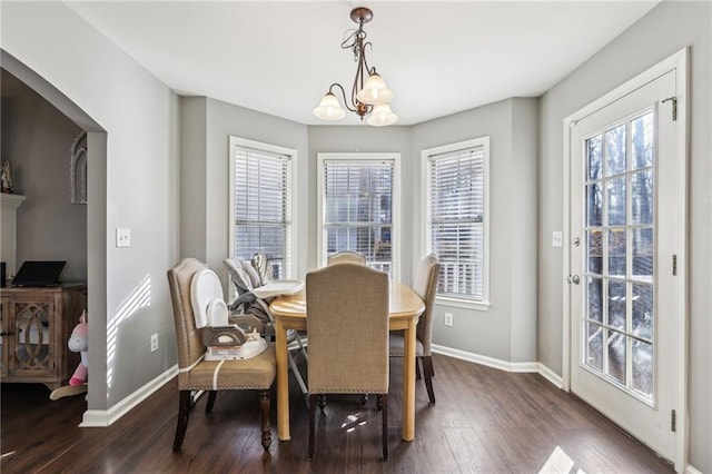 dining space with dark hardwood / wood-style flooring and a chandelier