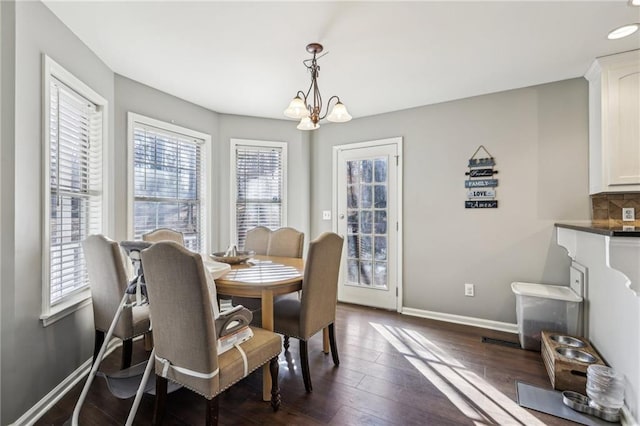 dining room with a notable chandelier and dark hardwood / wood-style flooring