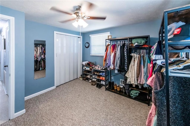 walk in closet with ceiling fan and carpet