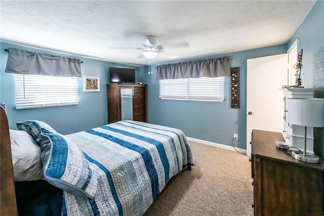 carpeted bedroom with a ceiling fan, baseboards, and a textured ceiling