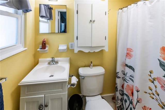 bathroom with toilet, vanity, and a shower with curtain