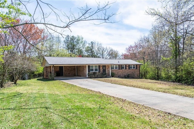 ranch-style home with a front lawn, an attached carport, brick siding, and concrete driveway
