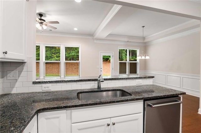 kitchen with white cabinets, decorative light fixtures, sink, and dark stone counters