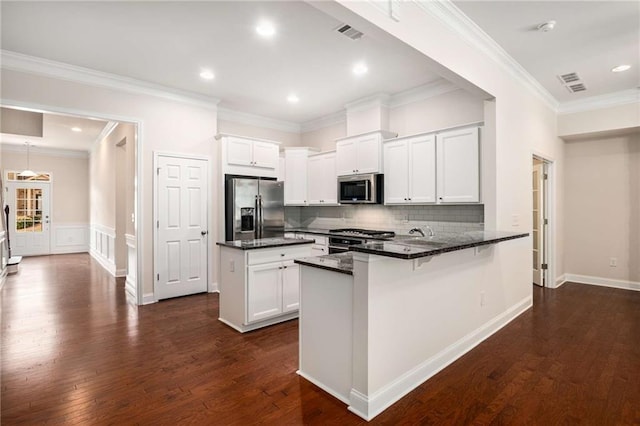 kitchen featuring kitchen peninsula, white cabinetry, stainless steel appliances, and ornamental molding