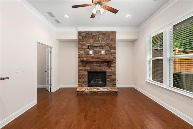 unfurnished living room featuring a stone fireplace, crown molding, ceiling fan, and dark wood-type flooring