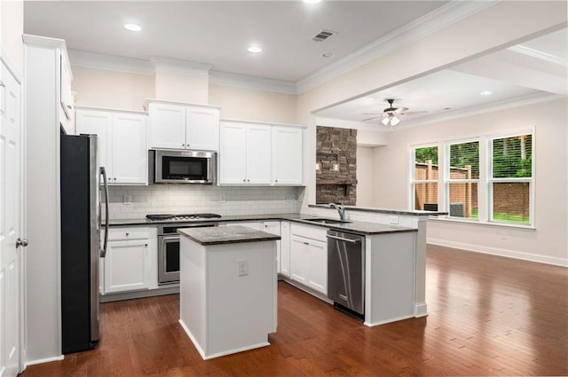 kitchen featuring white cabinets, a kitchen island, kitchen peninsula, and stainless steel appliances