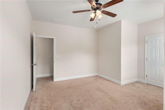 spare room featuring light carpet and ceiling fan