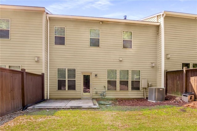 back of house featuring central AC unit, a patio, and a lawn