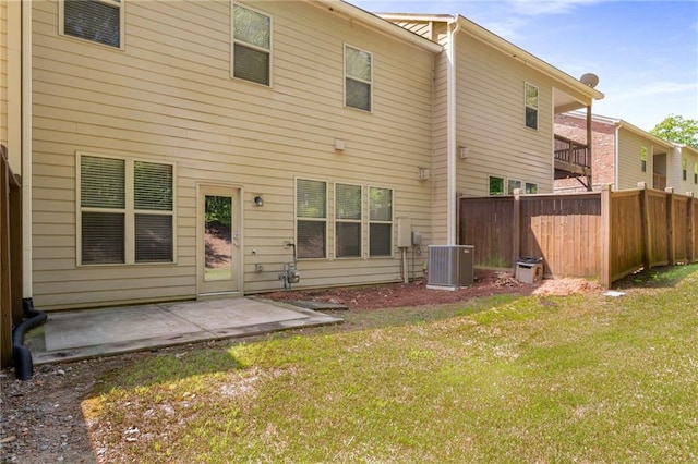 back of property with central air condition unit, a patio area, and a yard