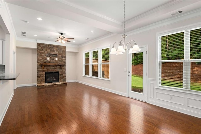 unfurnished living room with ceiling fan with notable chandelier, dark hardwood / wood-style flooring, crown molding, and a fireplace