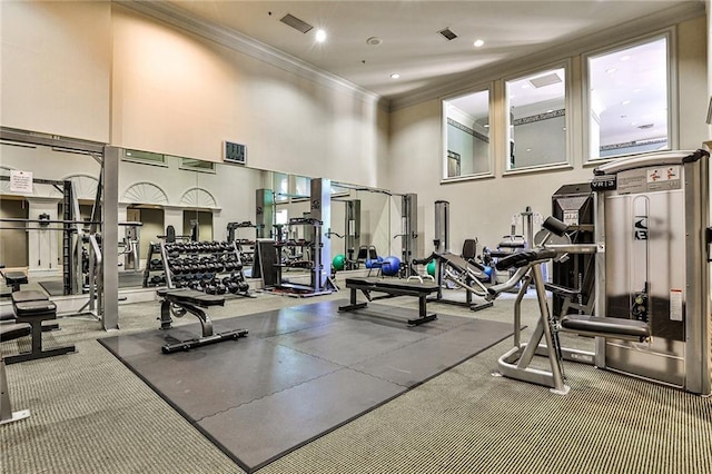 gym with a towering ceiling and ornamental molding