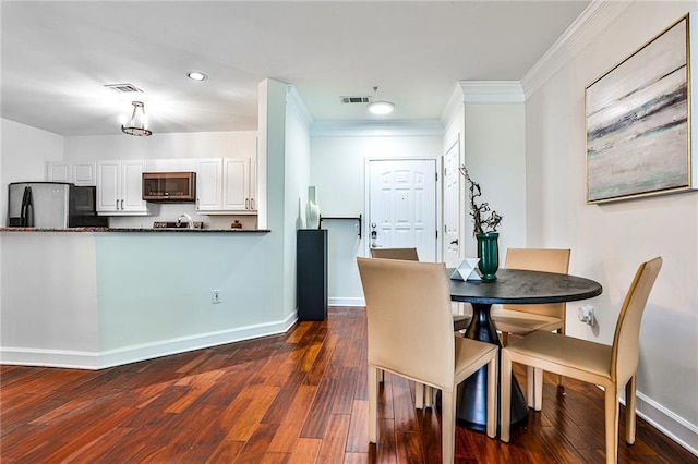 dining room featuring dark hardwood / wood-style floors and ornamental molding