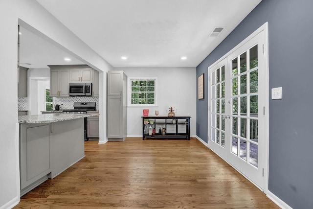 4066 Covered Bridge Rd SW, Smyrna, GA 30082 - kitchen with appliances with stainless steel finishes, gray cabinetry, tasteful backsplash, wood finished floors, and recessed lighting