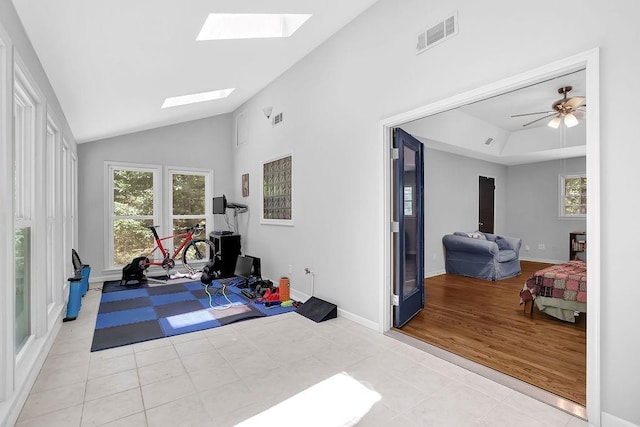 4066 Covered Bridge Rd SW, Smyrna, GA 30082 - workout area with light tile patterned floors, a skylight, vaulted ceiling, baseboards, and a tray ceiling