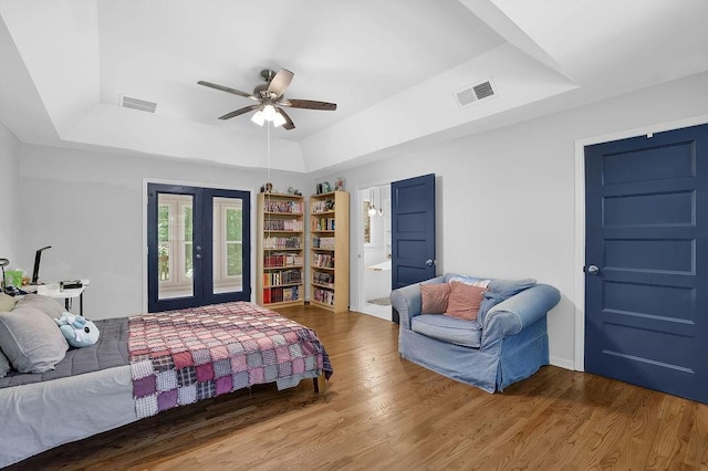 4066 Covered Bridge Rd SW, Smyrna, GA 30082 - bedroom with a tray ceiling, wood finished floors, french doors, ceiling fan, and ensuite bathroom