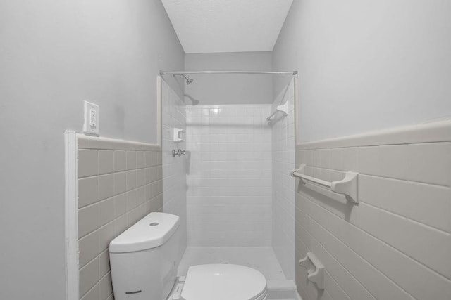 4066 Covered Bridge Rd SW, Smyrna, GA 30082 - full bath featuring tile walls, toilet, a tile shower, and wainscoting