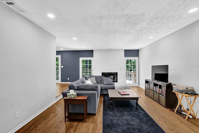 4066 Covered Bridge Rd SW, Smyrna, GA 30082 - living room featuring a brick fireplace, wood finished floors, a textured ceiling, recessed lighting, and baseboards