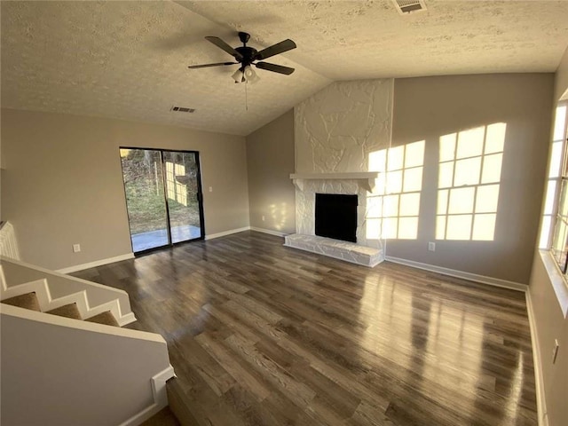 unfurnished living room featuring a fireplace, dark hardwood / wood-style floors, vaulted ceiling, and a textured ceiling