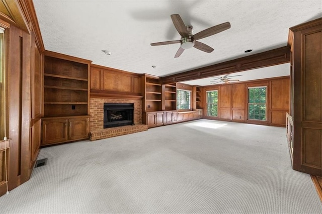 127 Roe Hampton Ln, Stone Mountain, GA 30087 - unfurnished living room with ceiling fan, a brick fireplace, wood walls, light colored carpet, and a textured ceiling