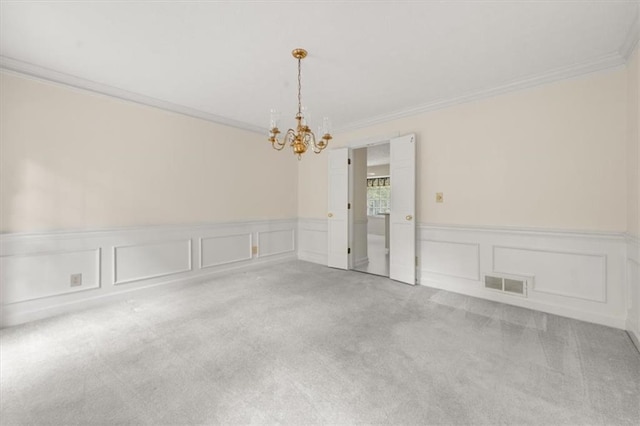 127 Roe Hampton Ln, Stone Mountain, GA 30087 - empty room featuring carpet flooring, crown molding, a decorative wall, a chandelier, and a wainscoted wall