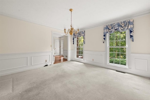 127 Roe Hampton Ln, Stone Mountain, GA 30087 - unfurnished dining area featuring carpet, a chandelier, wainscoting, a decorative wall, and crown molding