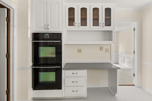 127 Roe Hampton Ln, Stone Mountain, GA 30087 - kitchen featuring white cabinetry, glass insert cabinets, crown molding, and a wainscoted wall