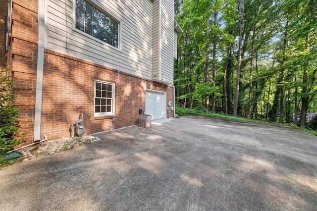 127 Roe Hampton Ln, Stone Mountain, GA 30087 - view of property exterior with driveway, brick siding, and a garage