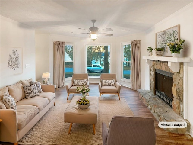 living room with a fireplace, wood finished floors, and a ceiling fan