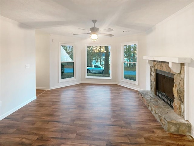 unfurnished living room with dark wood-style floors, plenty of natural light, a fireplace, and baseboards