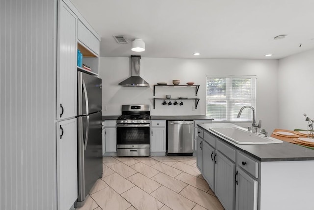kitchen featuring wall chimney range hood, open shelves, appliances with stainless steel finishes, and a sink