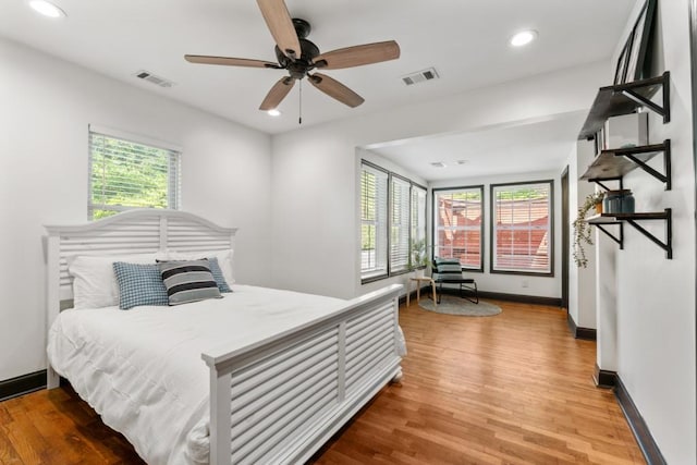 bedroom featuring multiple windows, visible vents, and wood finished floors