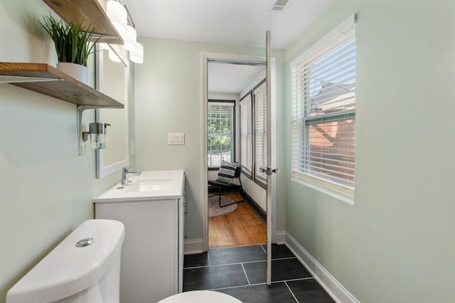 bathroom with toilet, tile patterned floors, visible vents, baseboards, and vanity