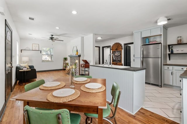 dining space featuring light wood-style flooring, recessed lighting, attic access, ceiling fan, and visible vents